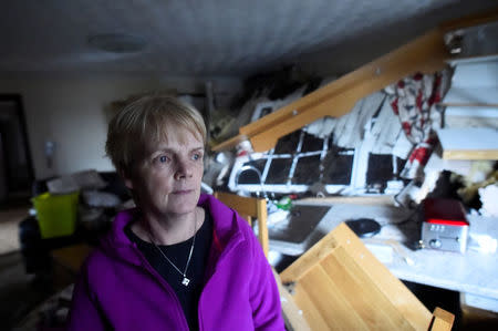 Bernie Kearney, a medical receptionist, poses for a photograph inside her home, which has been destroyed by a landslide of mud after torrential rains in Urris, County Donegal, Ireland August 24, 2017. REUTERS/Clodagh Kilcoyne