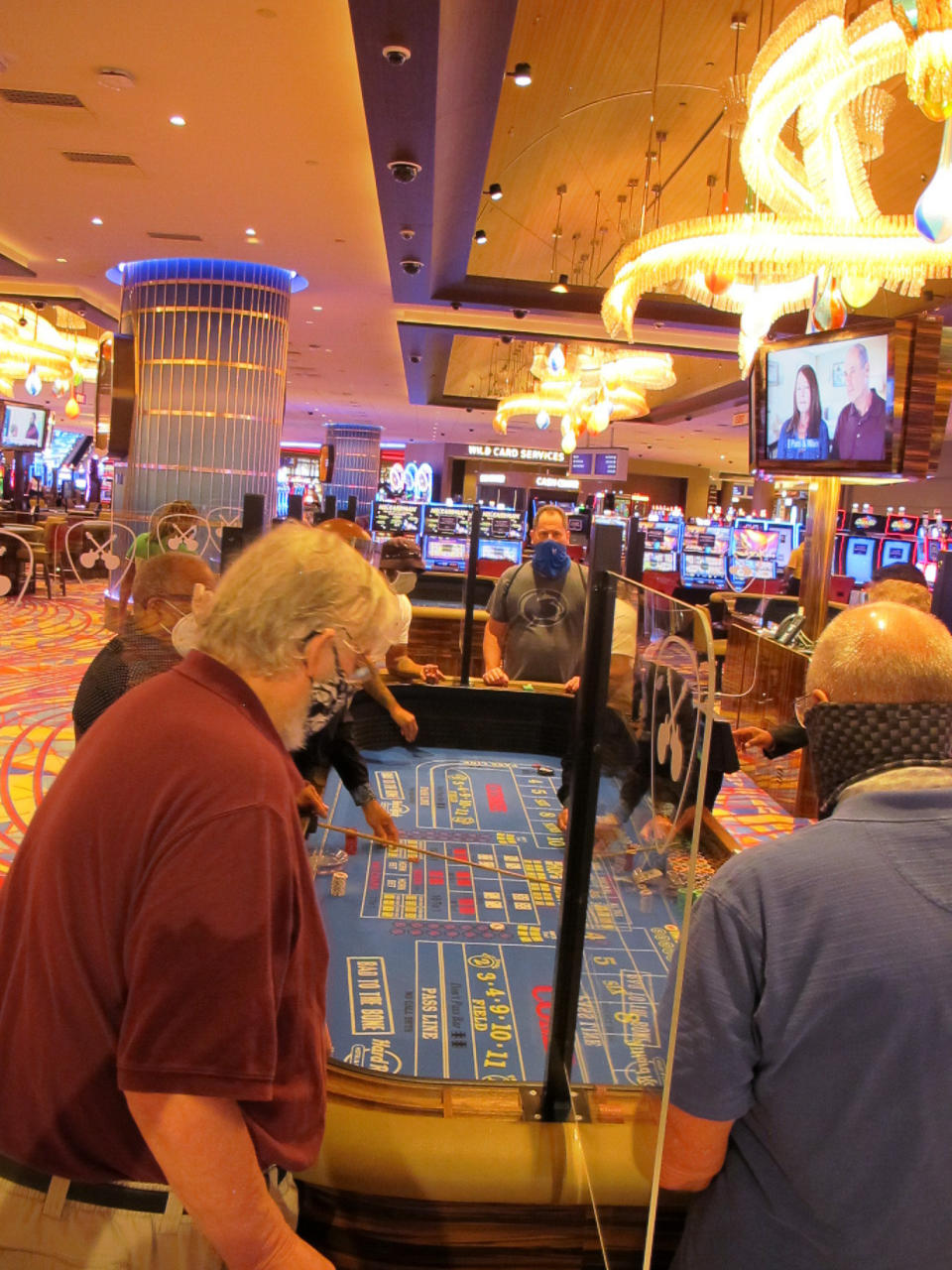 Gamblers play a game of craps at the Hard Rock casino in Atlantic City N.J. on July 2, 2020. On Sept. 14, 2020, New Jersey gambling regulators announced that New Jersey set a new national record for the amount wagered on sports in a single month in the U.S. with nearly $668 million bet on games. (AP Photo/Wayne Parry)