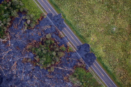 Lava flows across a highway on the outskirts of Pahoa during ongoing eruptions of the Kilauea Volcano in Hawaii, U.S., June 5, 2018. REUTERS/Terray Sylvester