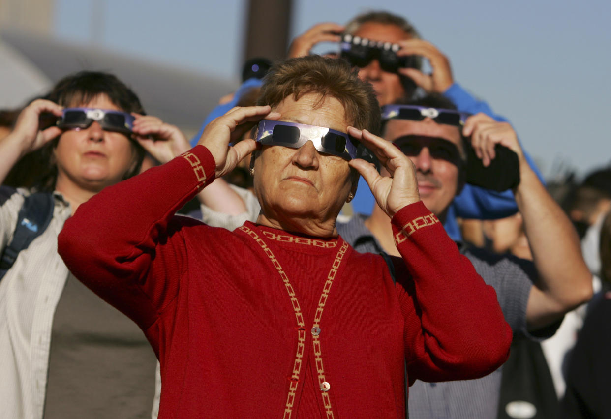 2005: People use protective glasses to view an annular eclipse at the Planetarium in Madrid. 