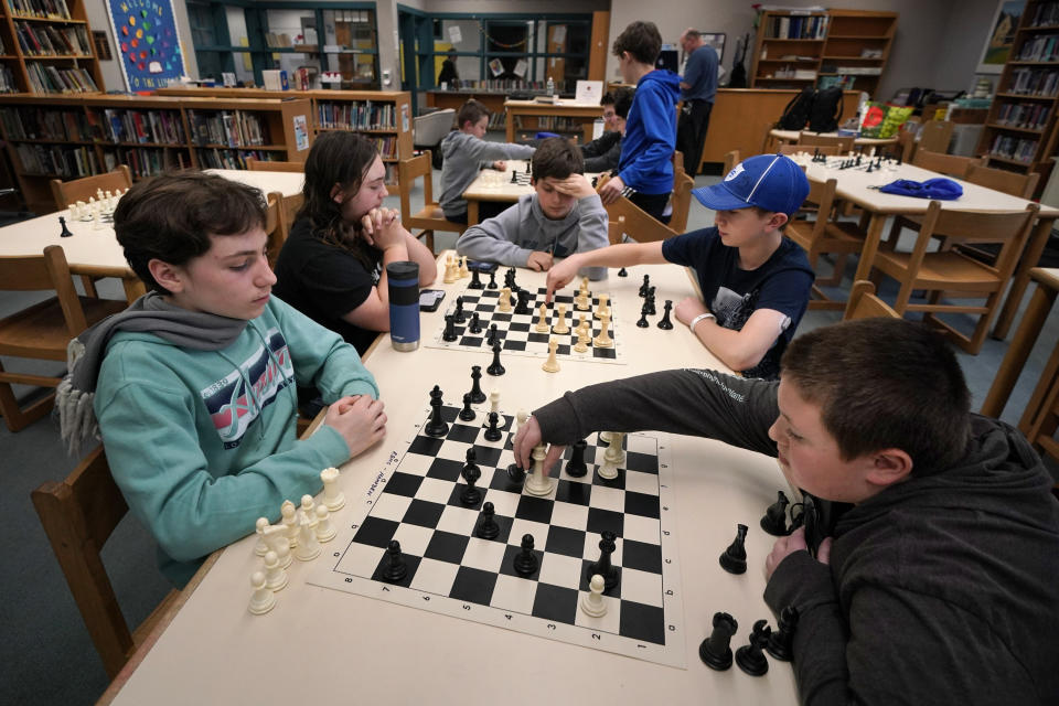Members of the Reeds Brook Middle School chess team practice at the Hampden Academy library, Tuesday, April 25, 2023, in Hampden, Maine. (AP Photo/Robert F. Bukaty)