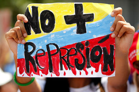A demonstrator holds up a banner that reads "No more repression" during a women's march to protest against President Nicolas Maduro's government in Caracas, Venezuela May 6, 2017. REUTERS/Christian Veron
