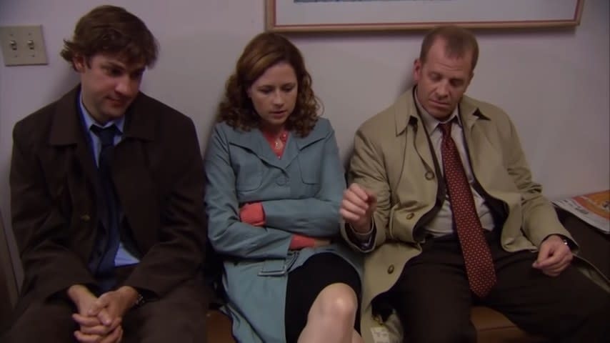 Toby with his hand hovering over Pam's knee while sitting next to her and Jim in "The Office"