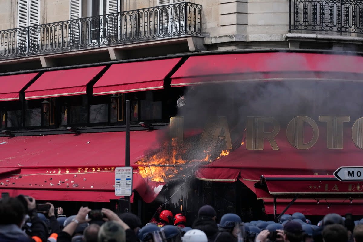 A restaurant awning burns in Paris on the latest day of strikes and protests  (AP)