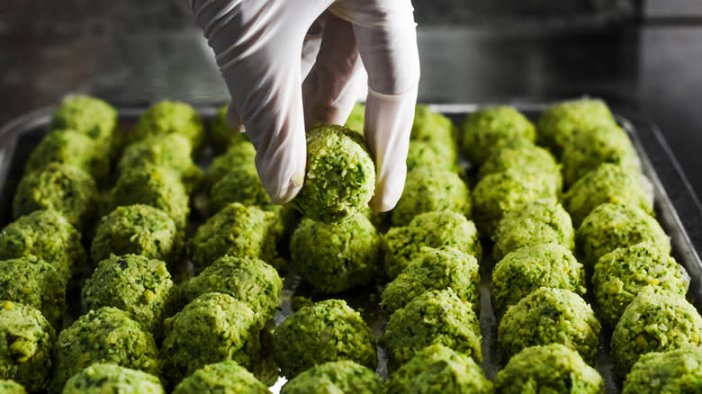 Falafel being placed on tray