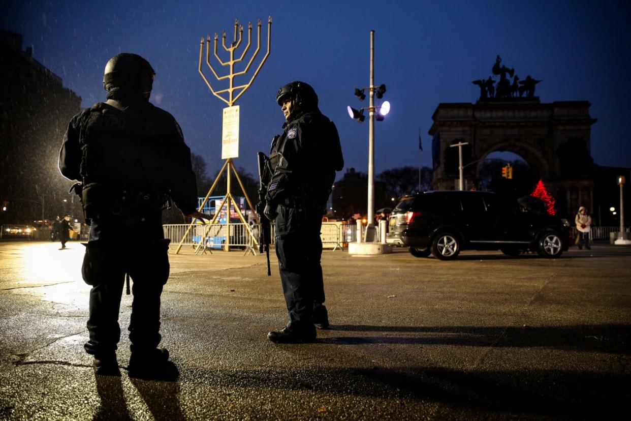 Image: New York Police officers stand guard ahead of a gathering at Brooklyn's Grand Army Plaza for the victims of a machete attack at a Hannukah celebration the day before in Monsey, N.Y., on Dec. 29, 2019.