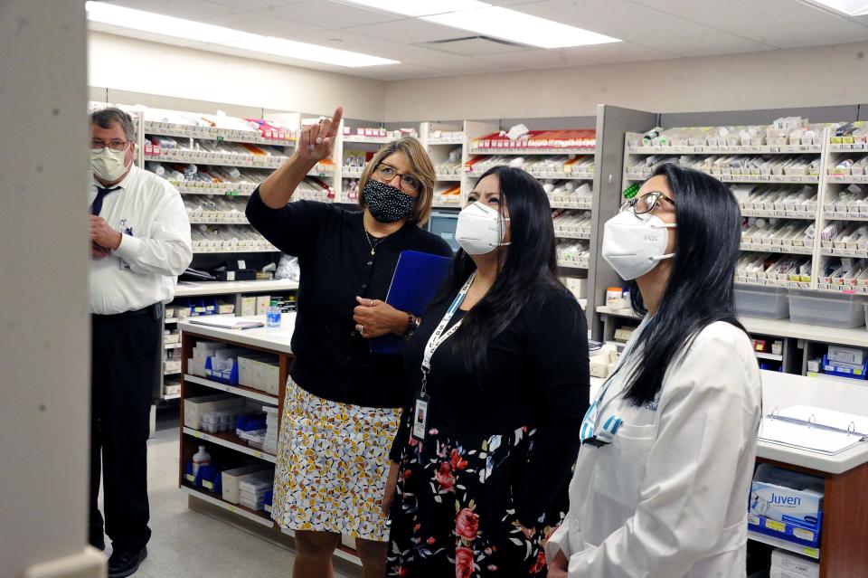 Wooster Community Hospital Director of Development Angela Rincon points to a patient medical tracking system in the hospital's in-house pharmacy while leading Lourdes Hernandez, center, and Dr. Marith Lopez on a tour. Hernandez and Lopez were visiting from a hospital in Honduras.