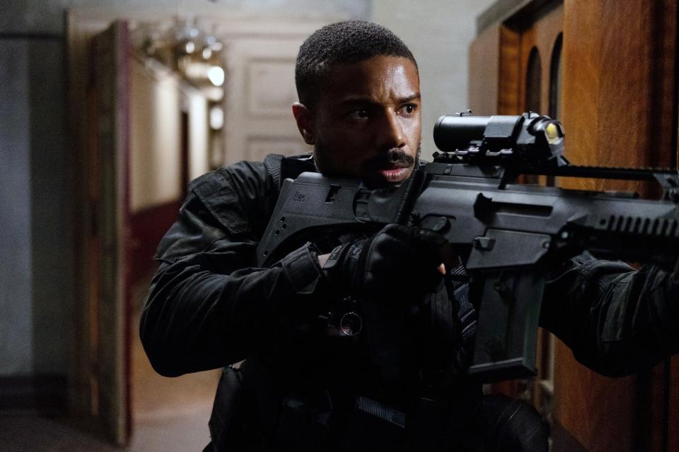 Michael B. Jordan holding an assault rifle.