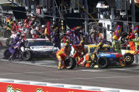 FILE - Kyle Busch, right, and Denny Hamlin make pit stops during the NASCAR Cup Series auto race Sunday, Nov. 10, 2019, in Avondale, Ariz. There is no sport that offers the same access to its stars or the action – teams can and do give spots on their pit stand to honorary guests ranging from friends, family or corporate partners – and it’s a critical cog in how NASCAR does business and what draws people to the races.(AP Photo/Ralph Freso, File)