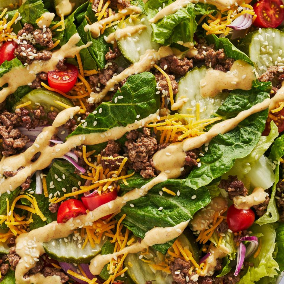 big mac salad with big mac sauce, cherry tomatoes, ground beef, and pickles