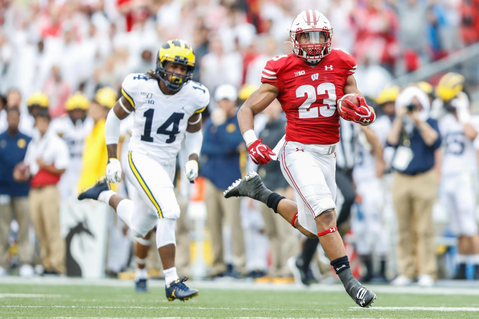 Wisconsin running back Jonathan Taylor (23) runs away from Michigan defensive back Josh Metellus (14) to score a touchdown during the Badgers' win on Saturday. (Getty)