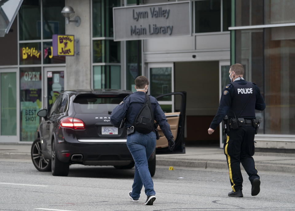 Members of the RCMP are seen outside of the Lynn Valley Library, in North Vancouver, B.C., Saturday, March 27, 2021. Police say multiple victims were stabbed inside and outside the library today. (Jonathan Hayward/The Canadian Press via AP)