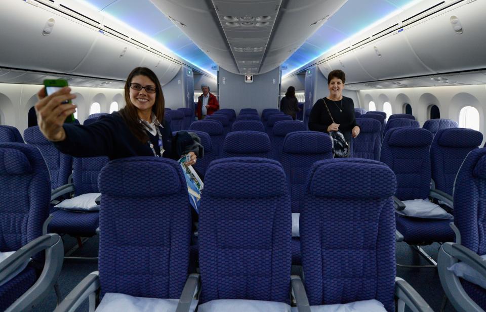 LOS ANGELES, CA - NOVEMBER 30: United Airlines customer service representative Desiree Yoos (L) takes a her picture inside the cabin while touring the new Boeing 787 Dreamliner at Los Angeles International Airport on November 30, 2012 in Los Angeles, California. In January the new jet is scheduled to begin flying daily non-stop between Los Angeles International airport and Japan's Narita International Airport and later to Shanghai staring in March. The new Boeing 787 Dreamliner will accomodate 219 travelers with 36 seats in United Business First, 70 seats in Economy Plus and 113 in Economy Class. The carbon-fiber composite material that makes up more than 50 percent of the 787 makes the plane more fuel-efficient. (Photo by Kevork Djansezian/Getty Images)