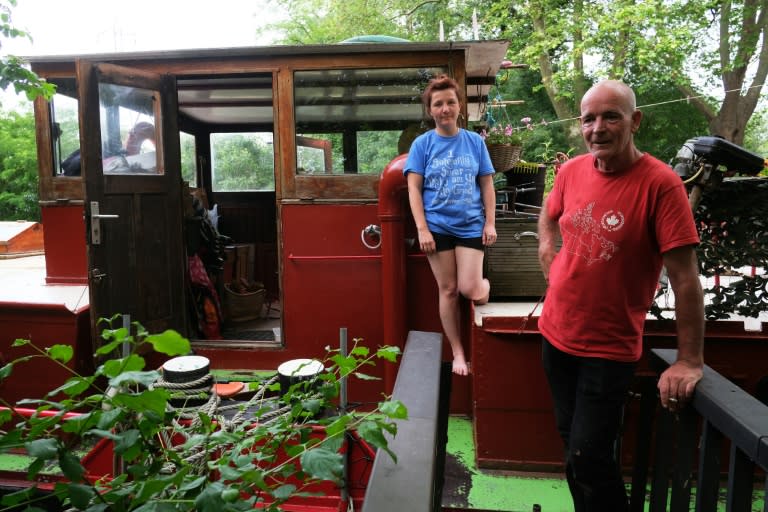 Emma Tissier, graphic designer, and her partner Caspar Galsworthy, craftsman, pose aboard their barge at the Port-Sud harbor, on the Canal du Midi in Ramonville, near Toulouse, southern France