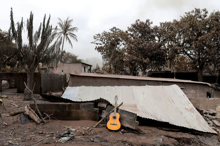 A guitar is seen on top of a roof of a house affected by the eruption of the Fuego volcano at San Miguel Los Lotes in Escuintla, Guatemala, June 8, 2018. REUTERS/Carlos Jasso