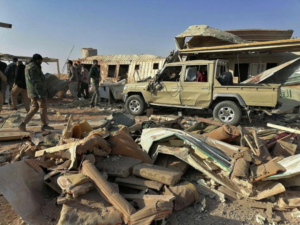 Fighters from the Kataeb Hezbollah, or Hezbollah Brigades militia, inspect the destruction at their headquarters in the aftermath of a U.S. airstrike in Qaim, Iraq, Monday, Dec. 30, 2019. The Iranian-backed militia said Monday that the death toll from U.S. military strikes in Iraq and Syria against its fighters has risen to 25, vowing to exact revenge for the "aggression of evil American ravens." (AP Photo)