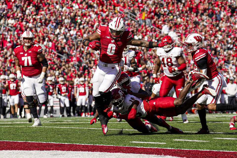 Wisconsin running back Braelon Allen (0) runs for a touchdown ahead of Rutgers defensive backs Flip Dixon (10) and Max Melton (16) during the first half of an NCAA college football game Saturday, Oct. 7, 2023, in Madison, Wis. (AP Photo/Andy Manis)