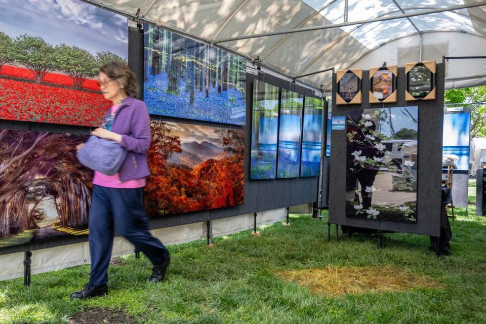 A visitor walks past a display of photos by Fred Mertz of Menlo Park, California, Friday before the start of the Brookside Art Annual.