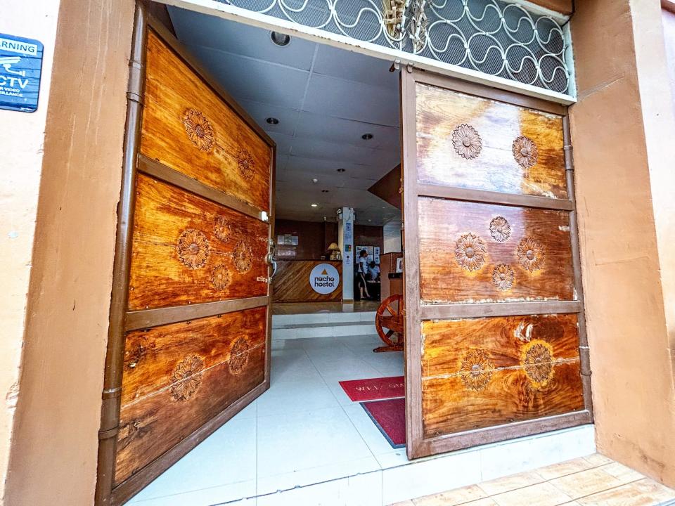 A large double door at the front of the hotel that leads into a lobby with a white tile floor.