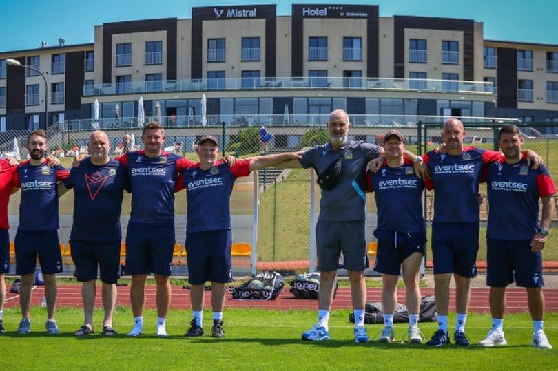 Photo shows Linfield's traditional staff photo including a space for late physio Paul Butler