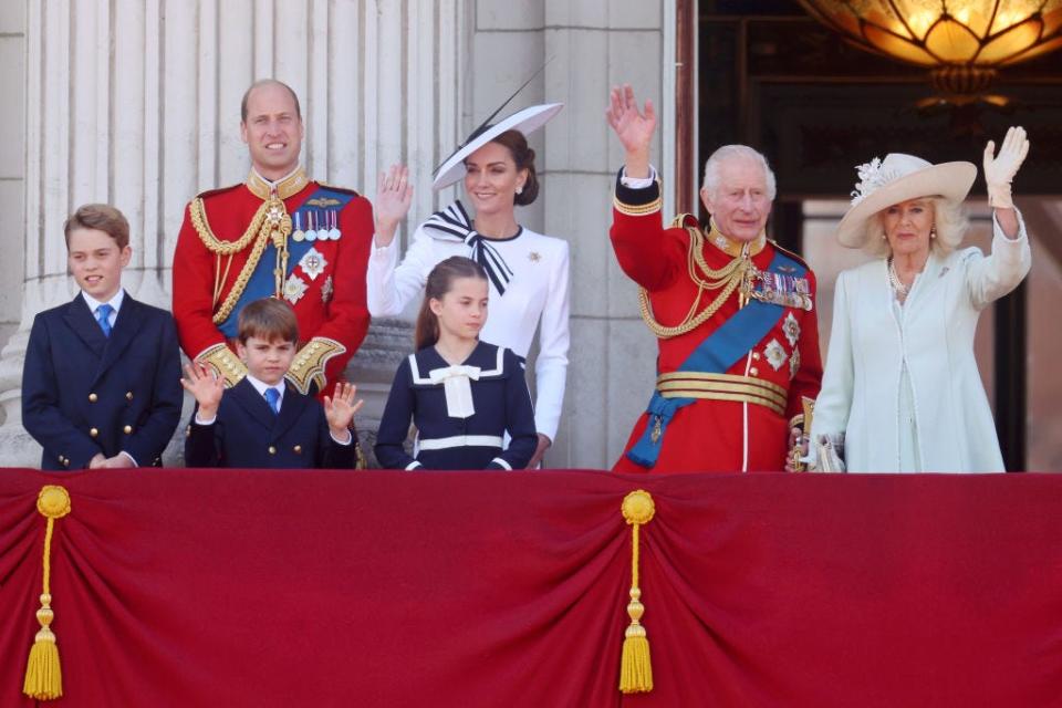 The British royal family waving from the balcony of Buckingham Palace.