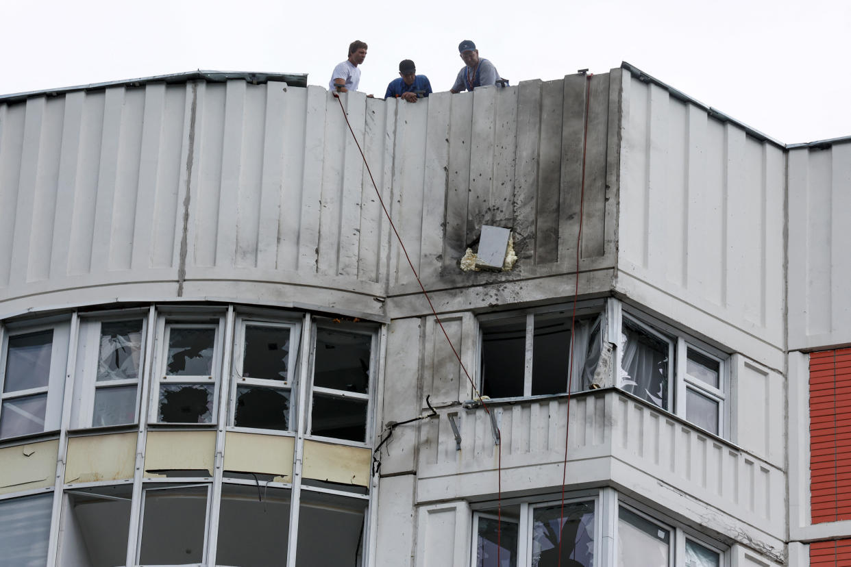 Men are seen on the roof of a damaged multi-storey apartment block following a reported drone attack in Moscow, Russia, May 30, 2023. (Maxim Shemetov/Reuters)