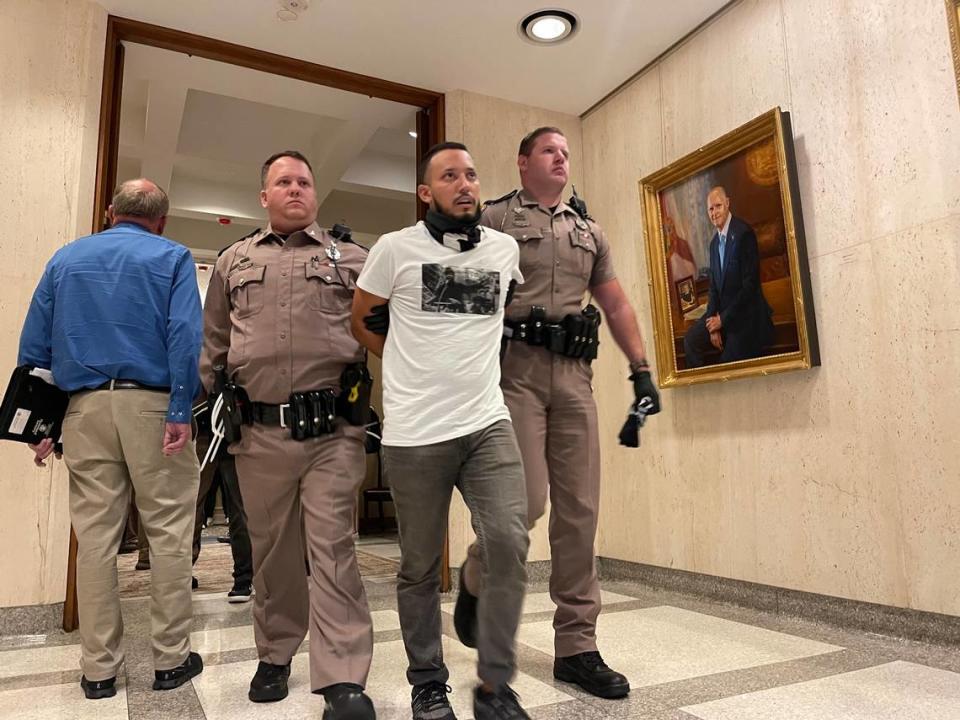 Un manifestante no identificado fue arrestado y escoltado fuera de la suite de la oficina del gobernador Ron DeSantis en el Capitolio de la Florida la noche del miércoles 3 de mayo de 2023.