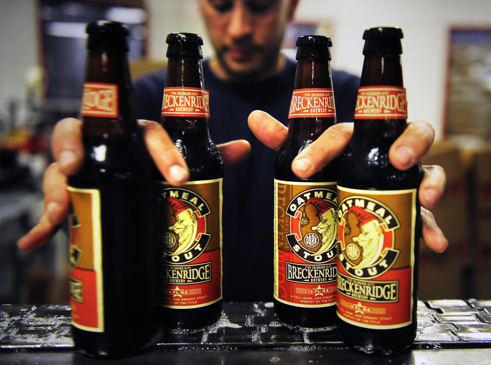 A man grabs four beers at a time on the bottling line at the Breckenridge Brewery.