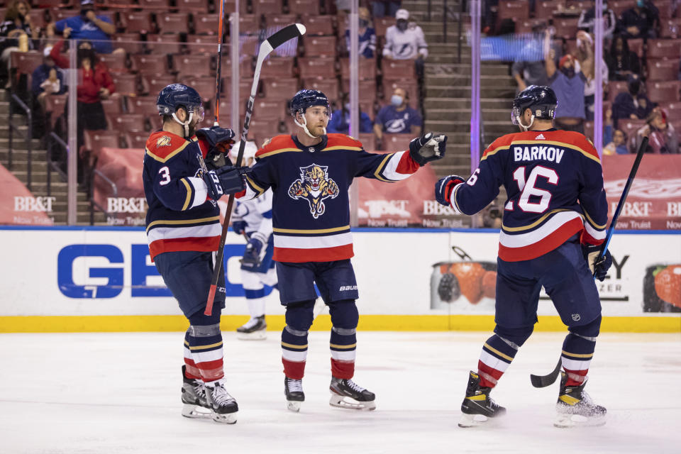 Florida Panthers center Sam Bennett (9) celebrates after scoring a goal with defenseman Keith Yandle (3) and center Aleksander Barkov (16) during the second period of an NHL hockey game against the Tampa Bay Lightning, Saturday, May 8, 2021, in Sunrise, Fla. (AP Photo/Mary Holt)