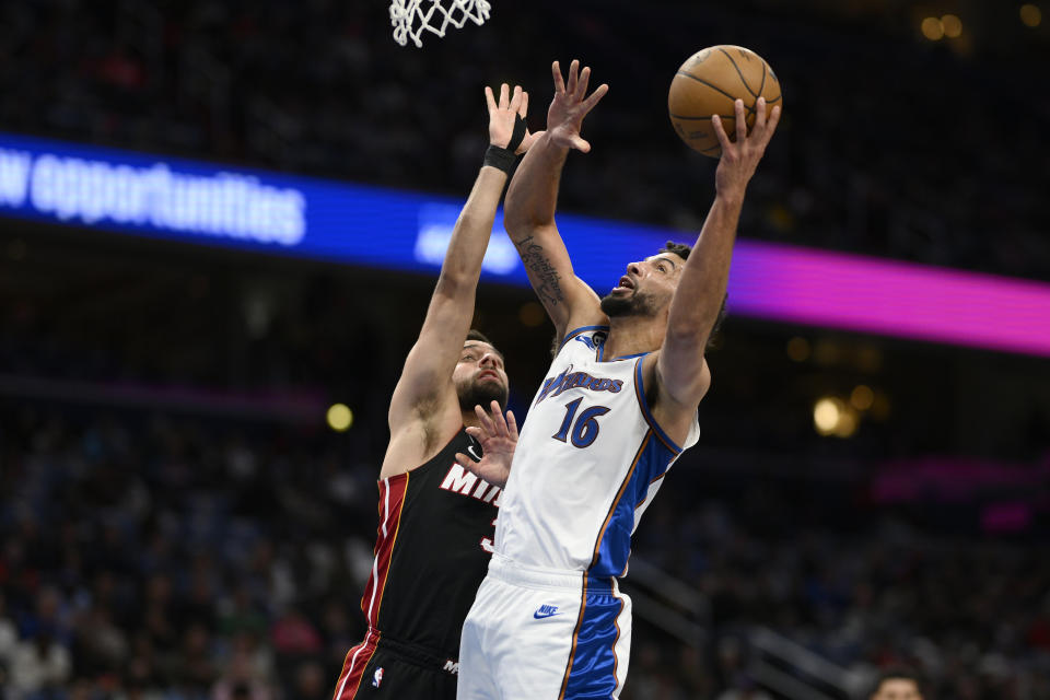 Washington Wizards forward Anthony Gill (16) goes to the basket against Miami Heat guard Max Strus during the first half of an NBA basketball game Friday, April 7, 2023, in Washington. (AP Photo/Nick Wass)