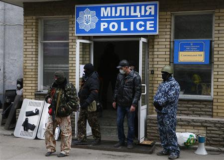 Armed men stand in front of the police headquarters building in Slaviansk, April 12, 2014. REUTERS/Gleb Garanich