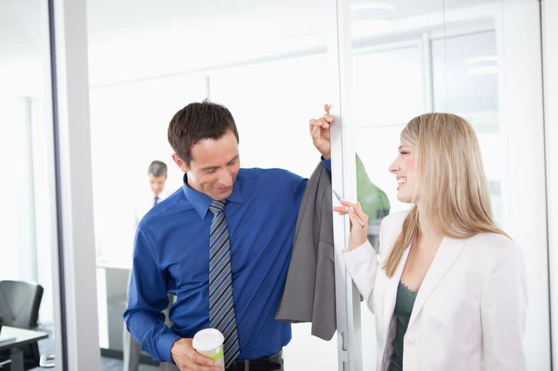 Businessman and businesswoman talking in doorway in office