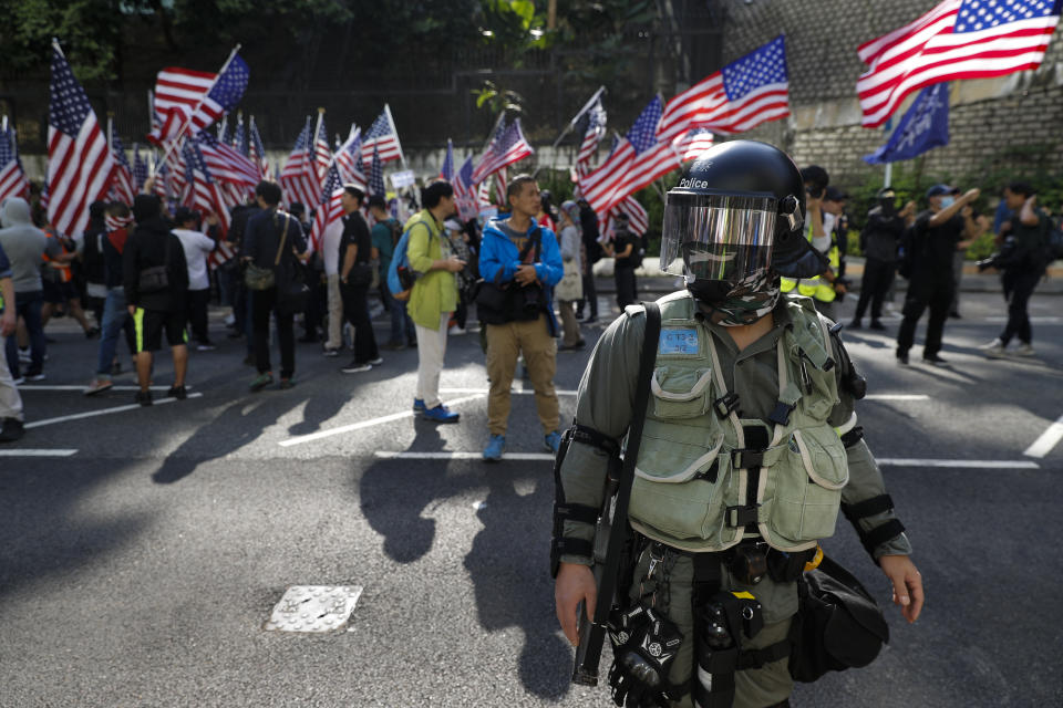 A riot policeman stands watch as protesters march to U.S. Consulate during a rally in Hong Kong, Sunday, Dec. 1, 2019. Hong Kong protesters carrying American flags and banners appealing to President Donald Trump rallied in the semi-autonomous Chinese territory. (AP Photo/Vincent Thian)