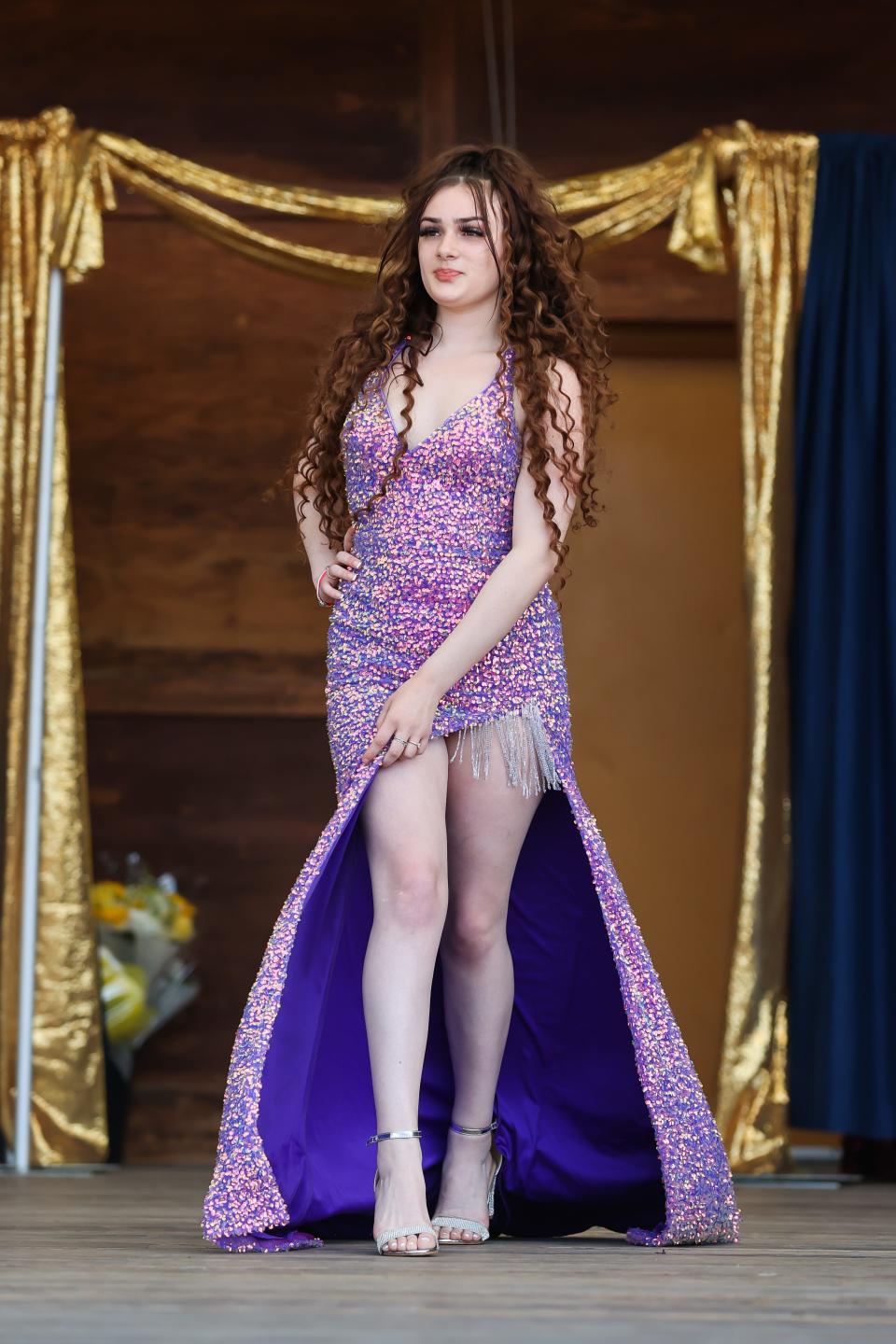 Malania Graichen, 16, of Cranston, Rhode Island, walks on stage wearing a purple sequin dress in the evening gown competition at the 77th Miss Hampton Beach Pageant.