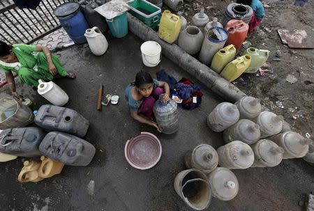 A girl waits to fill water in her containers from a municipal tap in New Delhi, India, February 21, 2016. REUTERS/Anindito Mukherjee