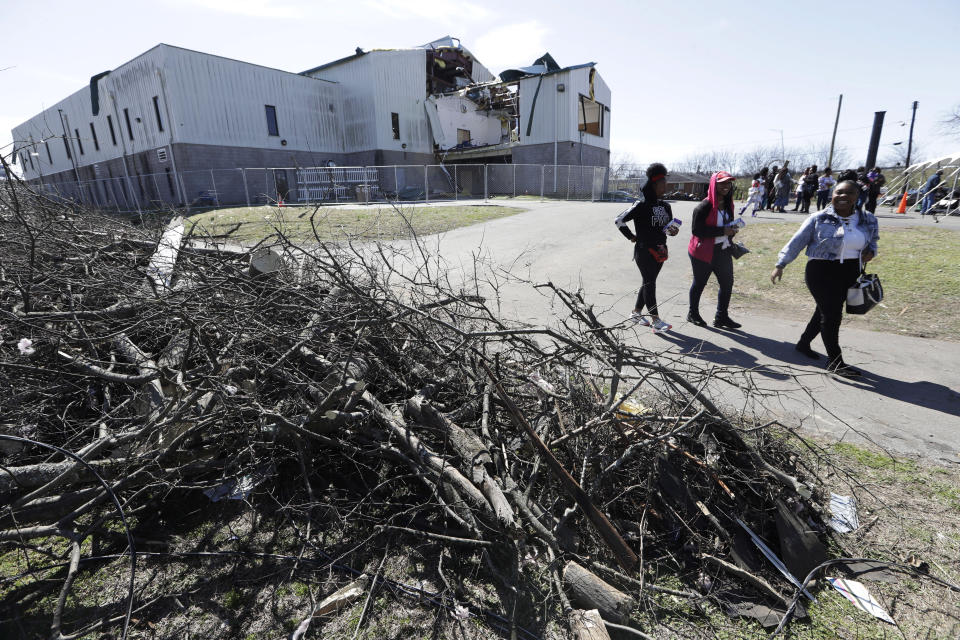 People walk by rubble as they leave a worship service at Mount Bethel Missionary Baptist Church, Sunday, March 8, 2020, in Nashville, Tenn. The congregation held their Sunday service in a tent in the parking lot near the church facilities, which were heavily damaged by a tornado March 3. (AP Photo/Mark Humphrey)