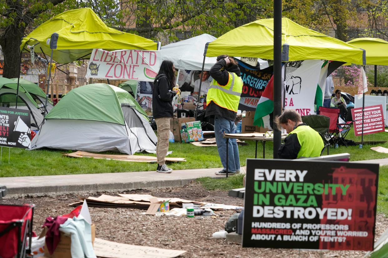 People talk among some of the approximately 40 tents and canopies set up outside Mitchell Hall on the University of Wisconsin-Milwaukee campus on Tuesday.