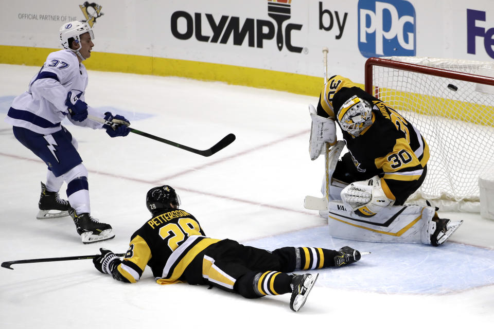 Tampa Bay Lightning's Yanni Gourde (37) puts the game-winning goal past Pittsburgh Penguins goaltender Matt Murray (30) with Marcus Pettersson (28) defending during the overtime period of an NHL hockey game in Pittsburgh, Tuesday, Feb. 11, 2020. The Lightning won in overtime 2-1. (AP Photo/Gene J. Puskar)