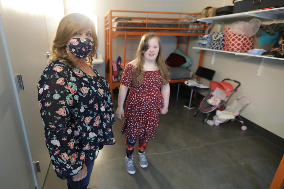 Connie Wade, left, poses for a photo with her daughter Emilyanne, 12, Wednesday, June 17, 2020, in their room at Mary's Place, a family homeless shelter located inside an Amazon corporate building on the tech giant's Seattle campus. The facility is home to the Popsicle Place shelter program, an initiative to address the needs of homeless children with life-threatening health conditions. (AP Photo/Ted S. Warren)