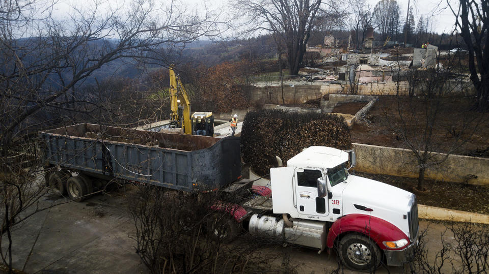 FILE - In this Feb. 8, 2019, file photo, an excavator loads debris onto a truck while clearing a property burned by the Camp Fire in Paradise, Calif. In the year since the fire, crews have removed more than 3.66 million tons of debris, twice the amount that was removed from the World Trade Center site following the 9/11 terrorist attacks. (AP Photo/Noah Berger, File)