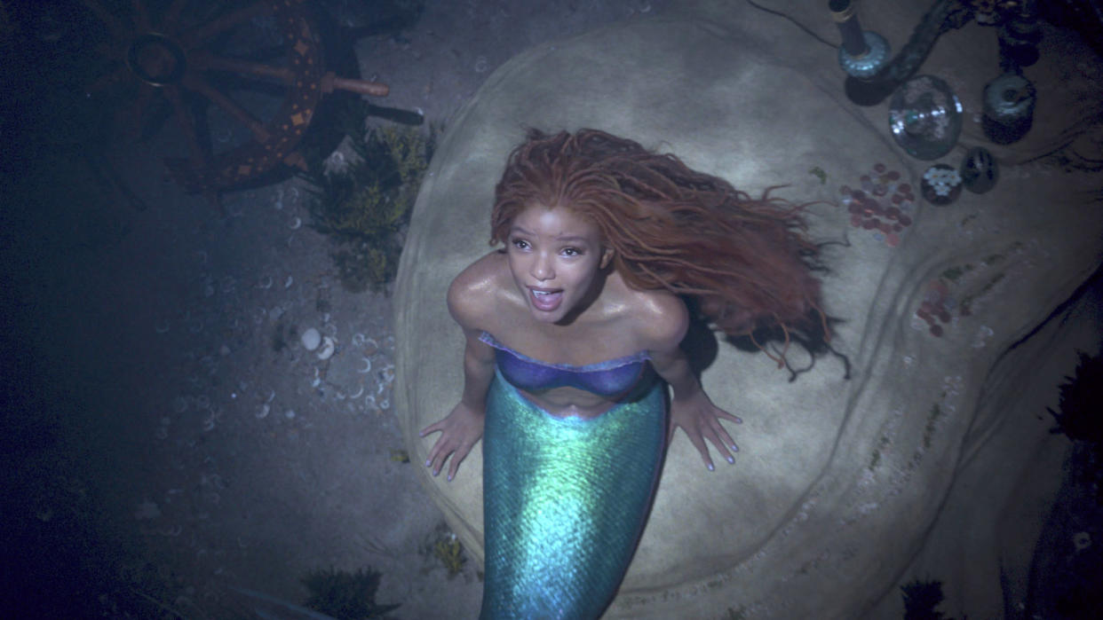  Ariel sits on a rock in the ocean as she sings in The Little Mermaid 