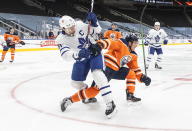 Edmonton Oilers' Tyson Barrie (22) and Toronto Maple Leafs' John Tavares (91) battle for the puck during first-period NHL hockey game action in Edmonton, Alberta, Monday, March 1, 2021. (Jason Franson/The Canadian Press via AP)