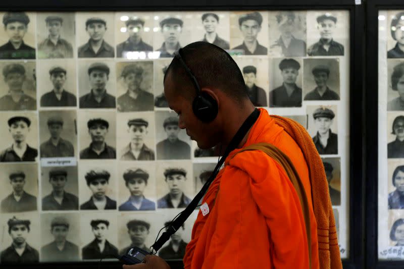 A Buddhist monk looks at pictures of victims of the Khmer Rouge regime at Tuol Sleng Genocide Museum in Phnom Penh