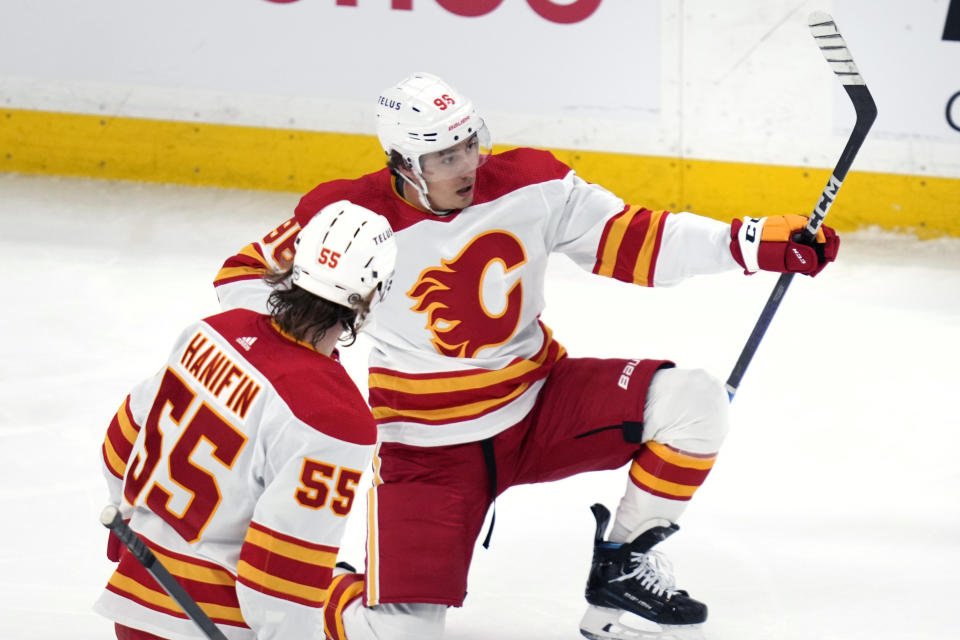 Calgary Flames forward Andrei Kuzmenko, rear, celebrates after his goal against Boston Bruins goaltender Jeremy Swayman during the first period of an NHL hockey game, Tuesday, Feb. 6, 2024, in Boston. (AP Photo/Charles Krupa)