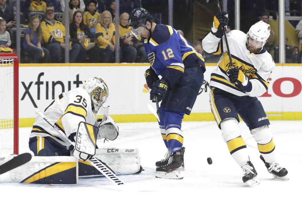 Nashville Predators goaltender Pekka Rinne (35), of Finland, blocks a shot as defenseman Yannick Weber (7), of Switzerland, and St. Louis Blues left wing Zach Sanford (12) watch for the rebound in the first period of an NHL hockey game Sunday, Feb. 16, 2020, in Nashville, Tenn. (AP Photo/Mark Humphrey)