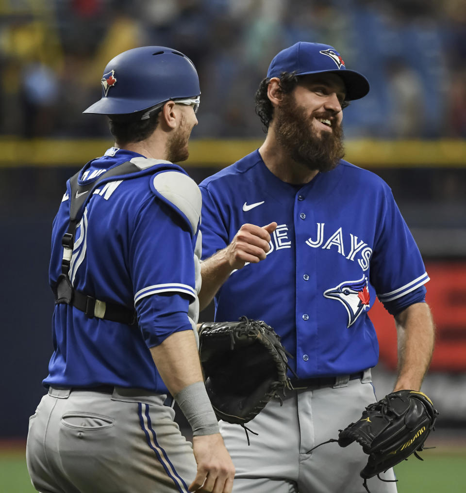 Toronto Blue Jays catcher Danny Jansen, left, and closer Jordan Romano celebrate a win over the Tampa Bay Rays in a baseball game Sunday, July 11, 2021, in St. Petersburg, Fla.(AP Photo/Steve Nesius)