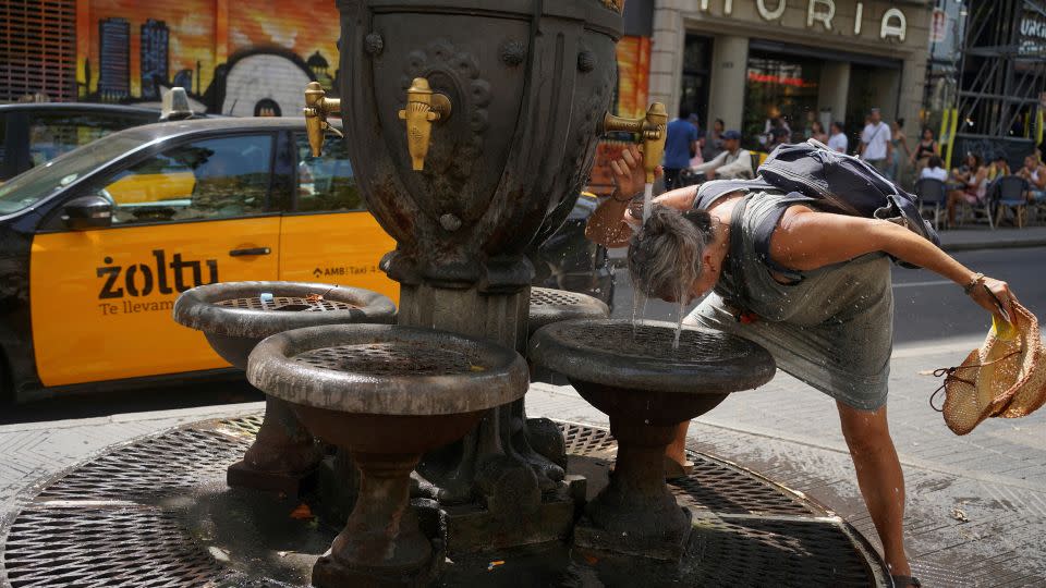 2023 年 7 月 19 日，西班牙巴塞罗那，一名游客在热浪中在喷泉里降温。- Bruna Casas/Reuters