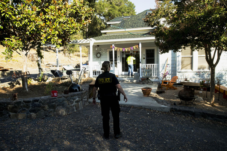 Healdsburg Police Officer Dean confirms residents have evacuated as a wildfire called the Kincade Fire burns nearby on Saturday, Oct. 26, 2019, in Healdsburg, Calif. Authorities issued evacuation orders for the town Saturday morning as the region braces for predicted strong, dry winds Saturday evening. (AP Photo/Noah Berger)