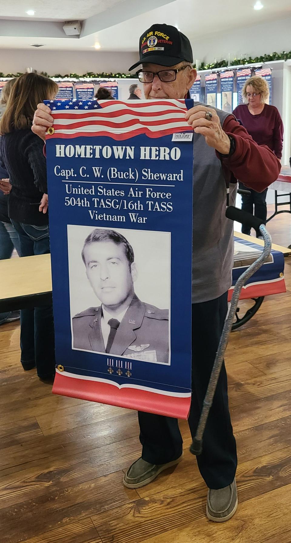 Captain Sheward served in the Air Force during the Vietnam War. He is seen here posing with his banner that will hang over the road in Frankfort.