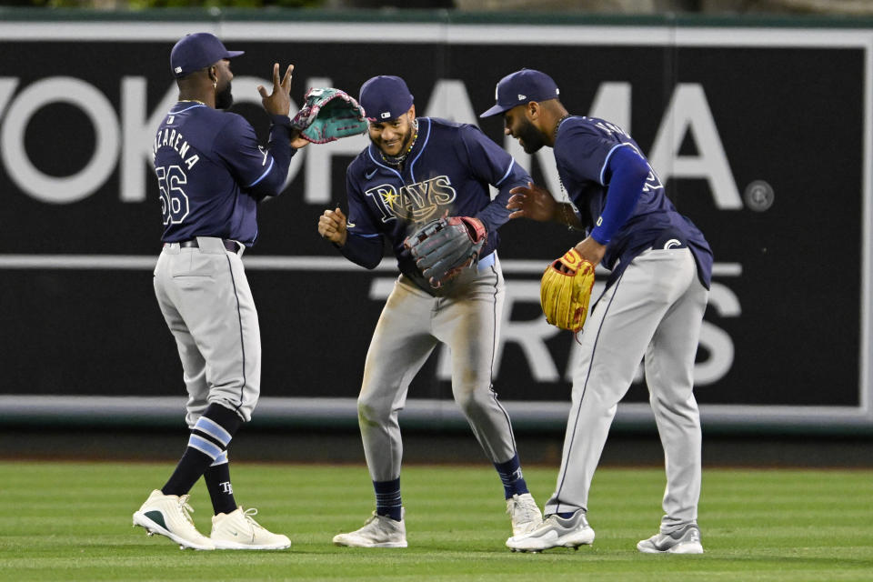 Tampa Bay Rays left tfielder Randy Arozarena, center fielder Jose Siri and right fielder Amed Rosario, from left, celebrate in the outfield after the Rays defeated the Los Angeles Angels in a baseball game in Anaheim, Calif., Tuesday, April 9, 2024. (AP Photo/Alex Gallardo)